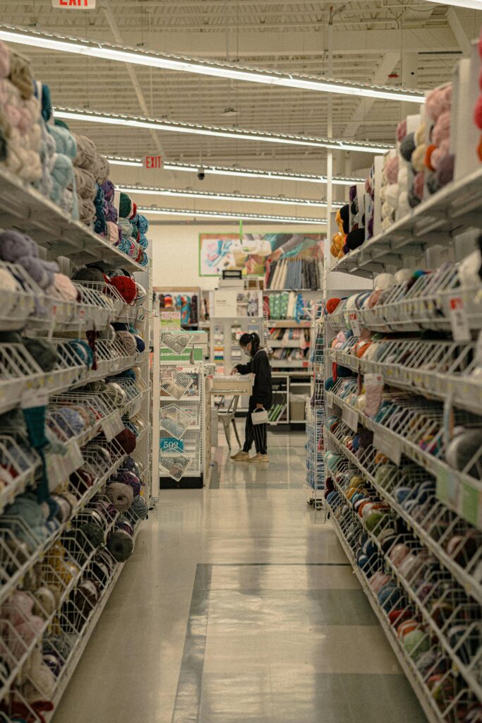 Casual worker stocking shelves and assisting customers in retail store